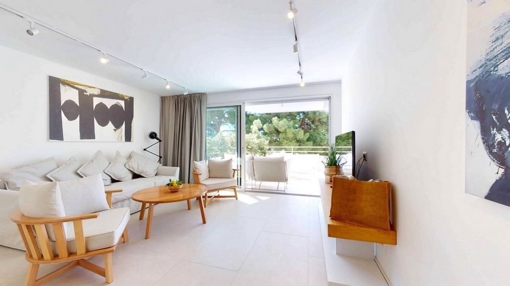 Mieszkanie w stanie surowym z widokiem z salonu z dużym oknem i wyjściem na balkon.