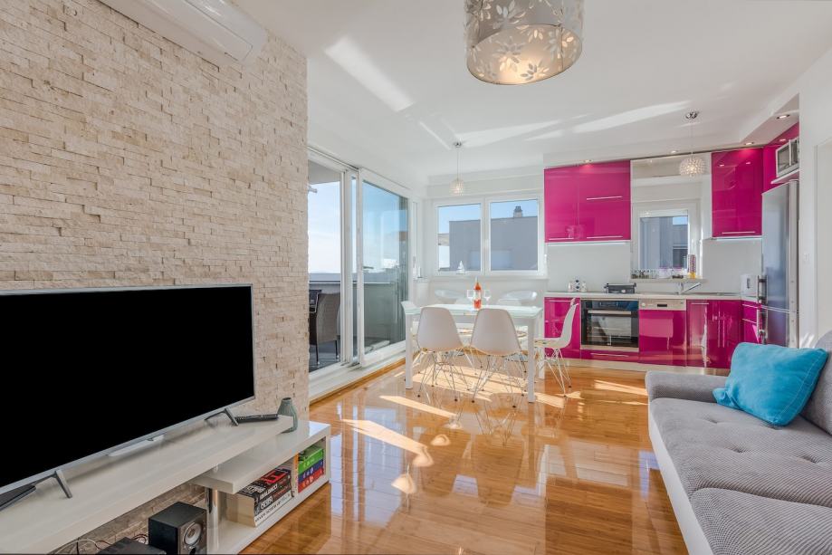 Część dzienna z widokiem na różową kuchnię.