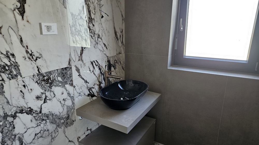 Nowoczesna łazienka z marmurowymi płytami na ścianie.
