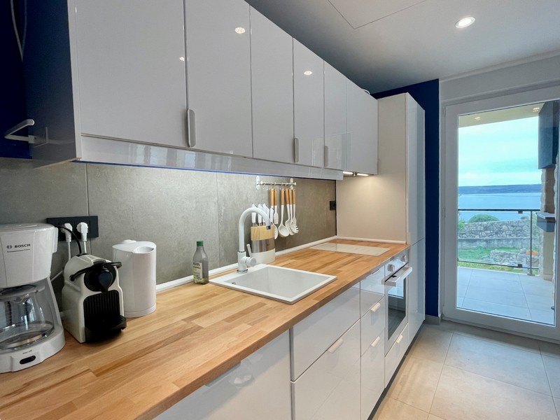 Widok z boku nowoczesnych żółtych budynków mieszkalnych z balkonami i kamiennymi detalami na sprzedaż w Zadarze, Chorwacja