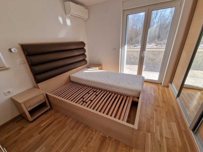 Podwójne łóżko w sypialni i widok na taras.