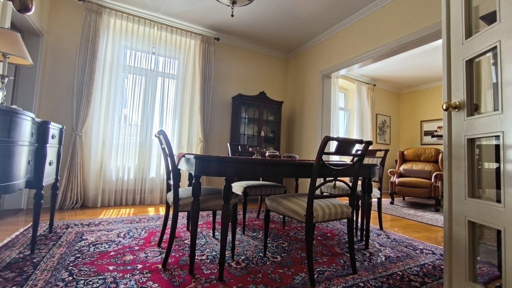 Część dzienna ze stołem jadalnym i dywanem.