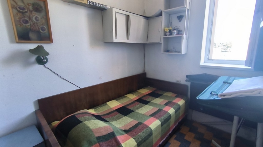 Mała sypialnia z łóżkiem pojedynczym.