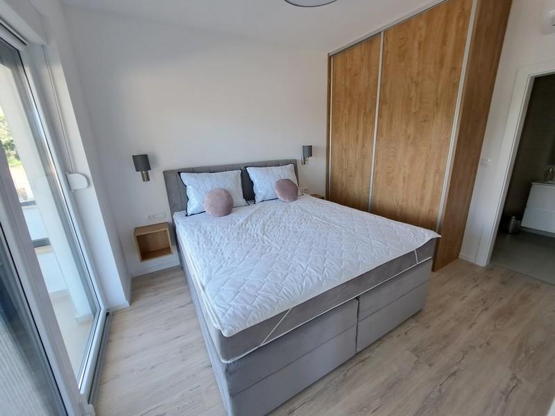 Przytulna i nowoczesna sypialnia z łóżkiem z materacem sprężynowym.