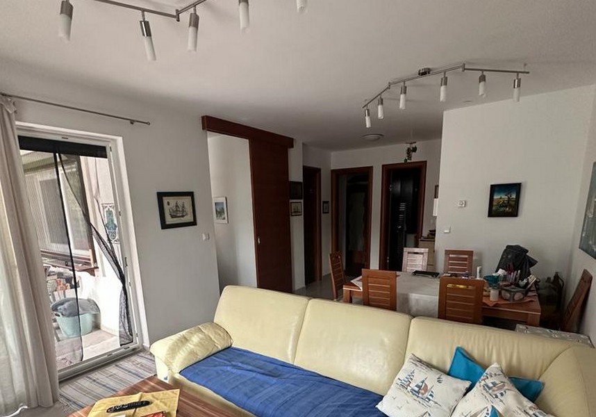 Umeblowany salon i widok na stół jadalny.