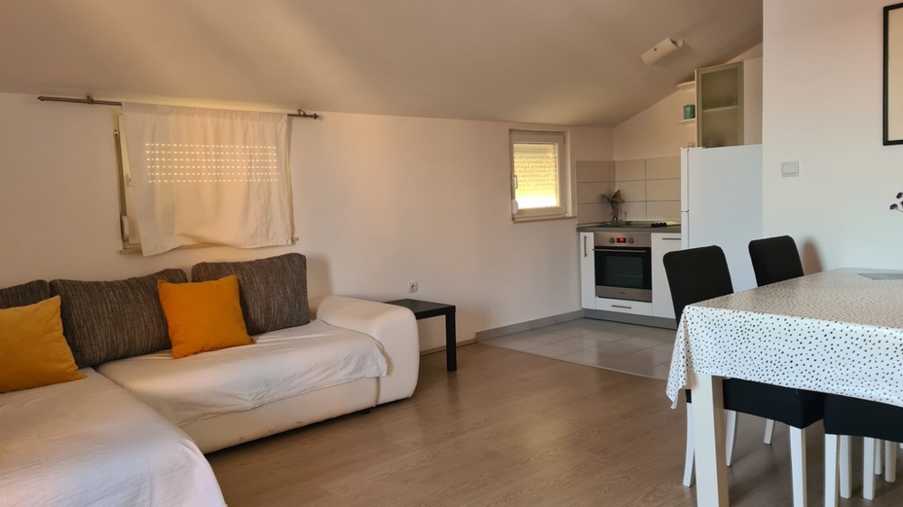 Część dzienna z aneksem kuchennym w nieruchomości A3004 na wyspie Pag w Chorwacji.