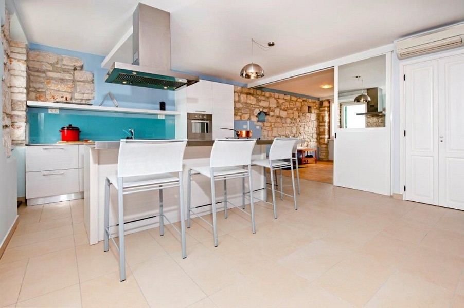 Nowoczesna kuchnia z turkusowym aneksem kuchennym.