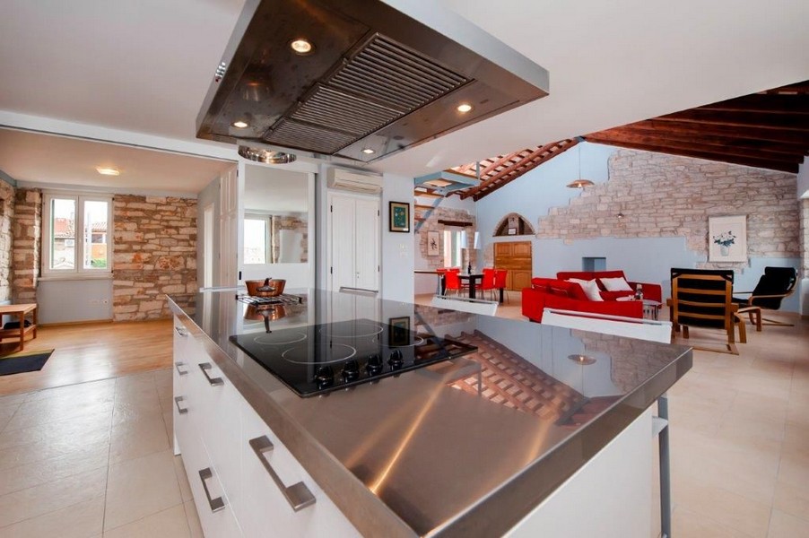 Wysokiej jakości wyspa kuchenna z kuchenką i widokiem na śródziemnomorski salon.