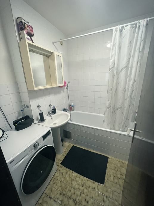 Łazienka z pralką i wanną.