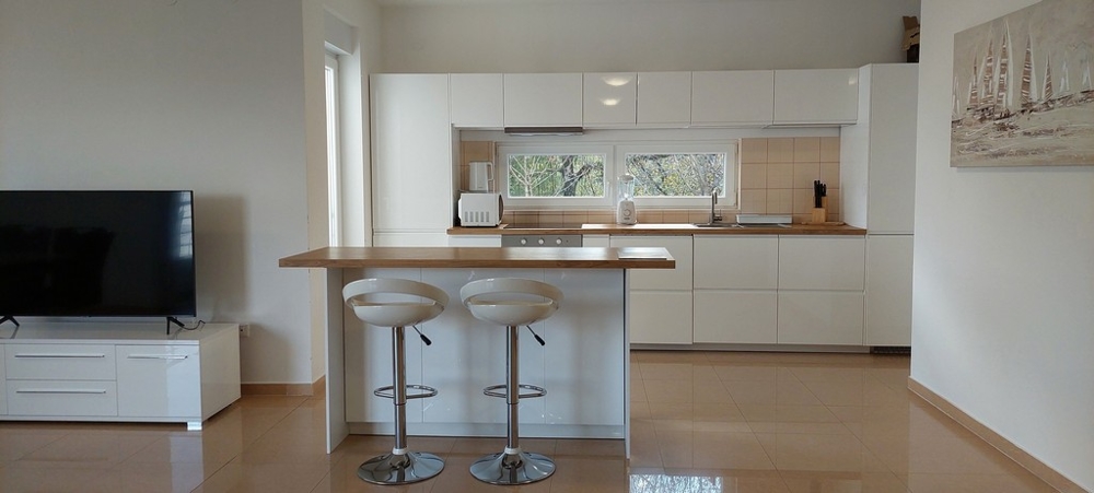 Otwarta kuchnia ze stołkami barowymi w wysokiej jakości mieszkaniu w Opatiji