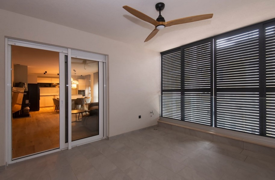 Widok z balkonu nowoczesnego mieszkania na sprzedaż w Splicie w Chorwacji, z przesuwanymi drzwiami i współczesnym designem.