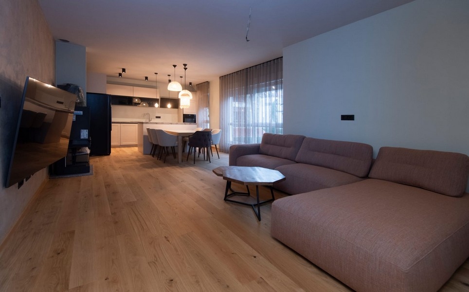 Przestronny i jasny salon w nowoczesnym apartamencie w Splicie w Chorwacji, z parkietem i eleganckimi meblami.