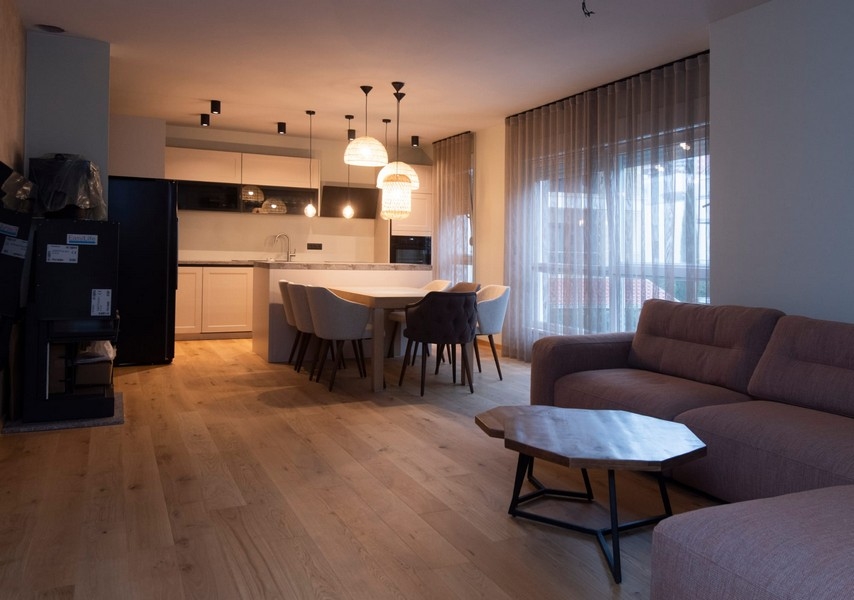 Elegancki i nowoczesny salon z przejściem do kuchni w mieszkaniu w Splicie w Chorwacji, idealny do rozrywki.