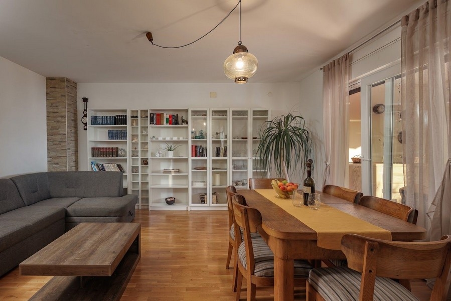 Salon i jadalnia z półką na książki i dużym stołem w chorwackiej posiadłości.