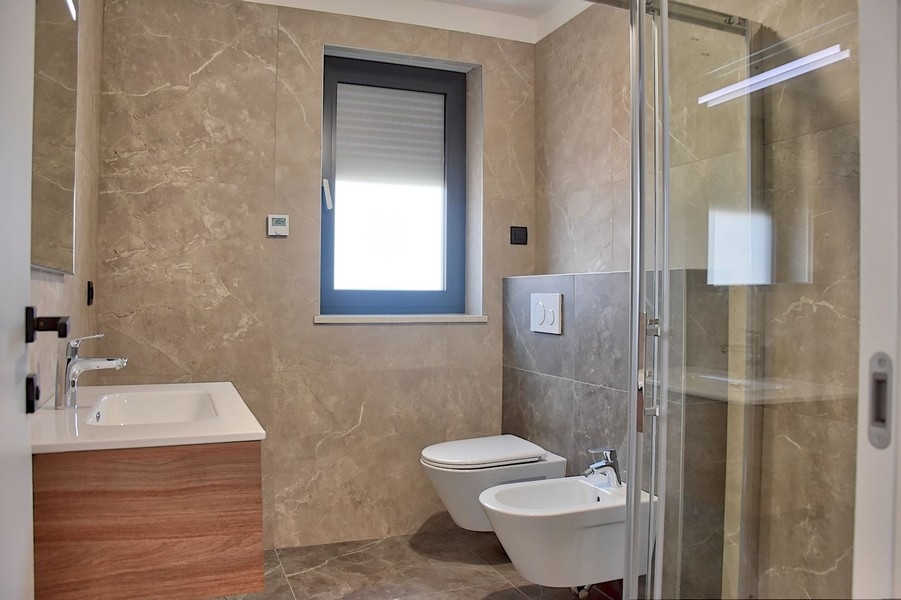 Na sprzedaż elegancka łazienka w penthousie na Istrii, z nowoczesną armaturą i marmurowymi płytkami.