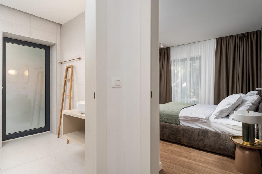 Przytulna sypialnia w luksusowym apartamencie na Istrii z bezpośrednim dostępem do łazienki i nowoczesnym wnętrzem