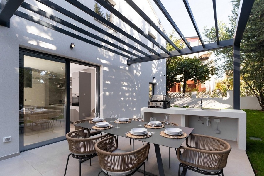 Zadaszony taras luksusowego apartamentu na Istrii z letnią kuchnią i jadalnią na świeżym powietrzu