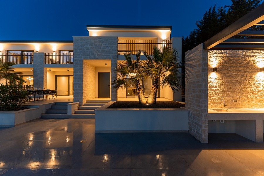 Teren zewnętrzny luksusowej nieruchomości na Istrii z letnią kuchnią i oświetleniem