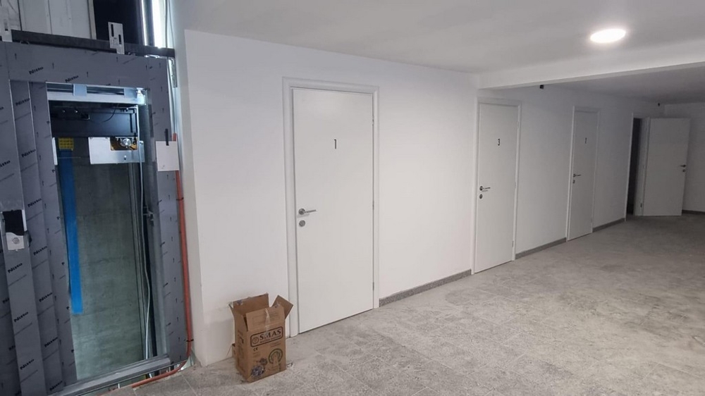 Przedpokój w chorwackiej posiadłości z białymi drzwiami i windą po lewej stronie zdjęcia.