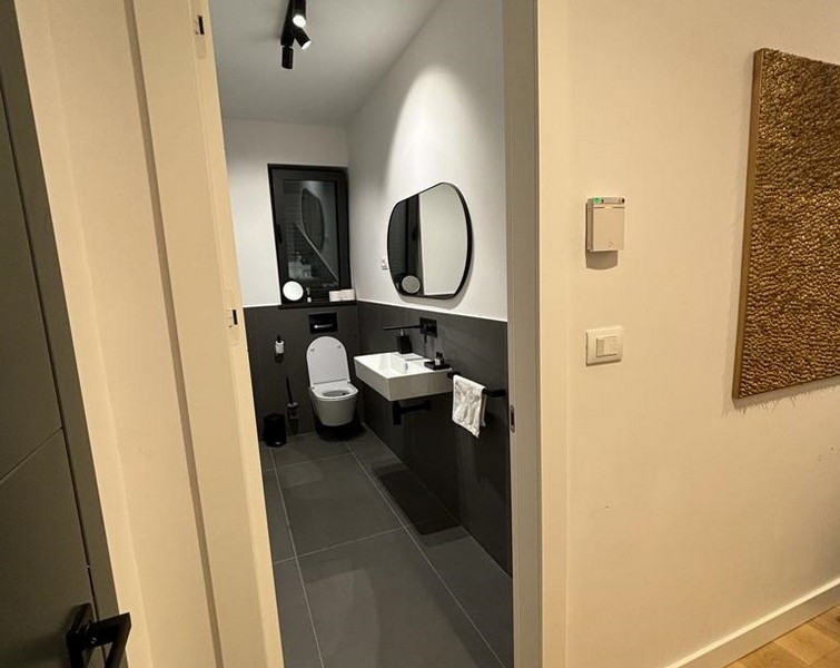 Nowoczesna łazienka z szarymi kafelkami i lustrami, nieruchomość na sprzedaż w Rijece w Chorwacji.