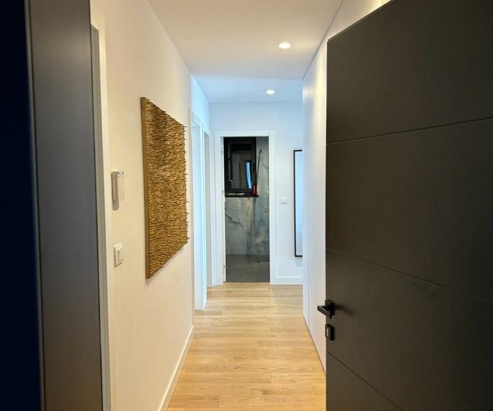 Przedpokój w mieszkaniu z drewnianą podłogą i ścianą artystyczną na sprzedaż w Rijece w Chorwacji.