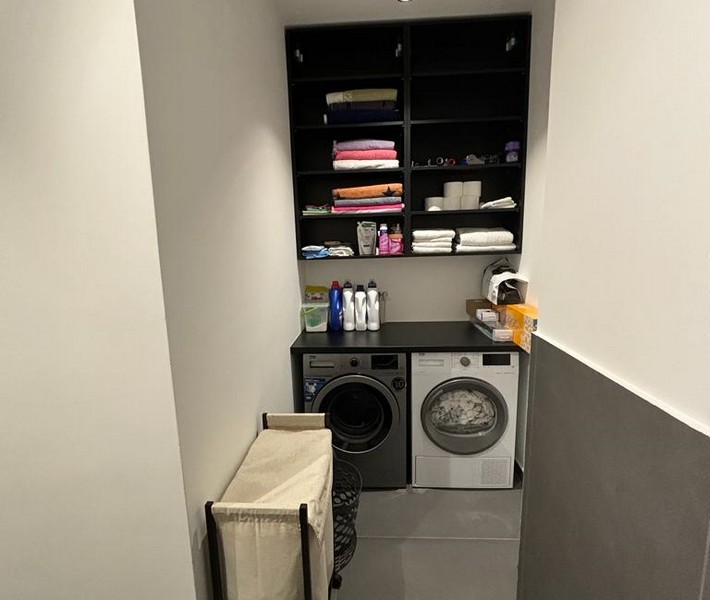 Pralnia z pralką i wbudowaną szafką na ręczniki, część mieszkania na sprzedaż w Rijece, Chorwacja.