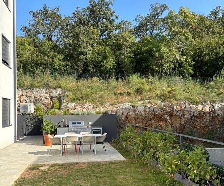 Ogród z kuchnią na świeżym powietrzu i miejscami do siedzenia, część mieszkania na sprzedaż w Rijece w Chorwacji.