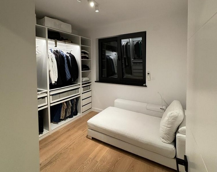 Kompaktowy pokój gościnny z białą rozkładaną sofą i wbudowaną szafą, nieruchomość w Rijece w Chorwacji.