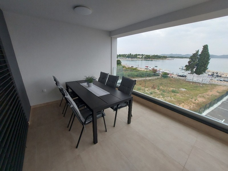 Jadalnia ze stołem i krzesłami w apartamencie na sprzedaż w Zadarze w Chorwacji, z widokiem na morze