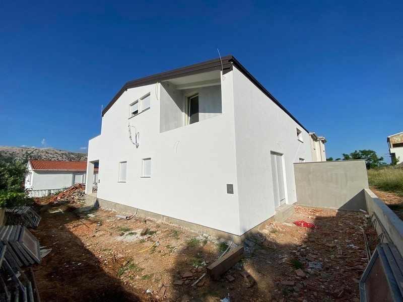 Wnętrze mieszkania na sprzedaż w Pag w Chorwacji, w stanie surowym z widocznymi elementami murowymi i narzędziami budowlanymi