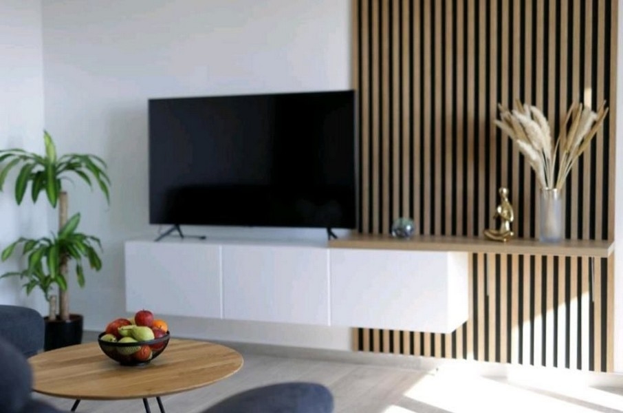 Stylowy widok na salon z nowoczesnym stojakiem na telewizor i dekoracjami w mieszkaniu, na sprzedaż w pobliżu Opatiji w Chorwacji