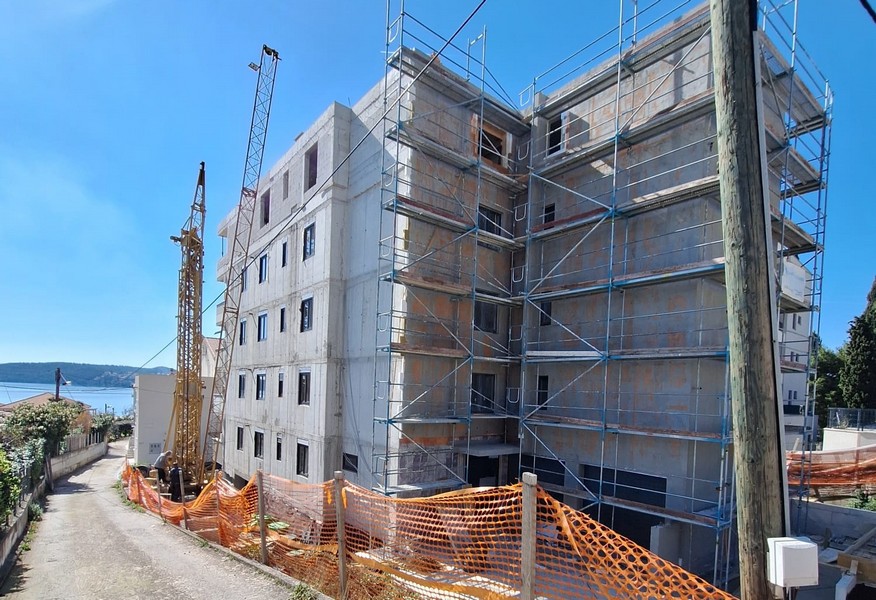 Widok z tyłu budynku mieszkalnego w budowie z rusztowaniem i dźwigiem w Chorwacji, oferowany przez Panorama Scouting