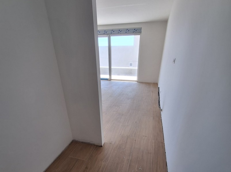 Puste, gotowe do zamieszkania mieszkanie z drewnianymi podłogami i oknem wychodzącym na balkon w Chorwacji, oferowane przez Panorama Scouting