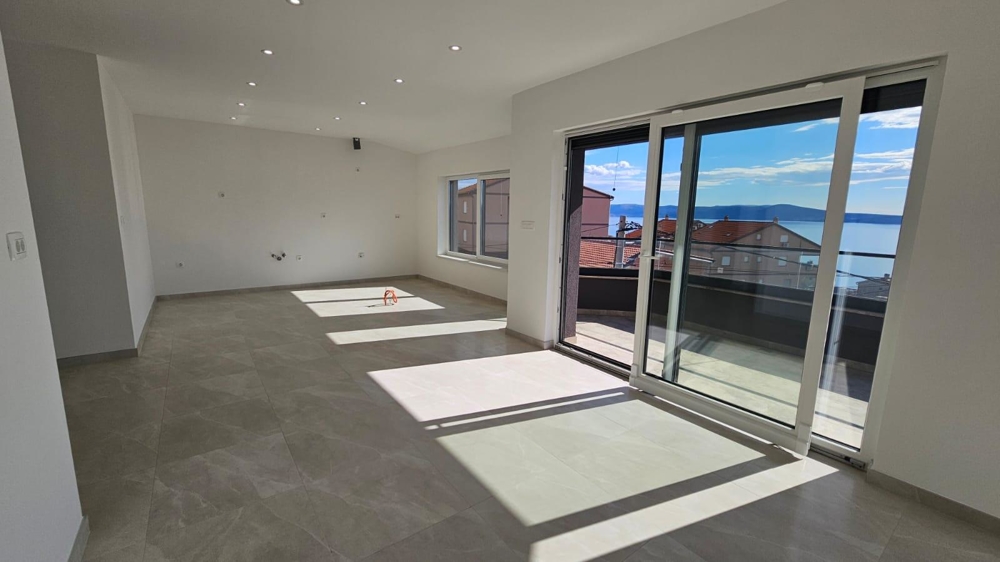 Nasłoneczniony salon mieszkania na sprzedaż w Crikvenicy z dostępem do balkonu i widokiem na wybrzeże