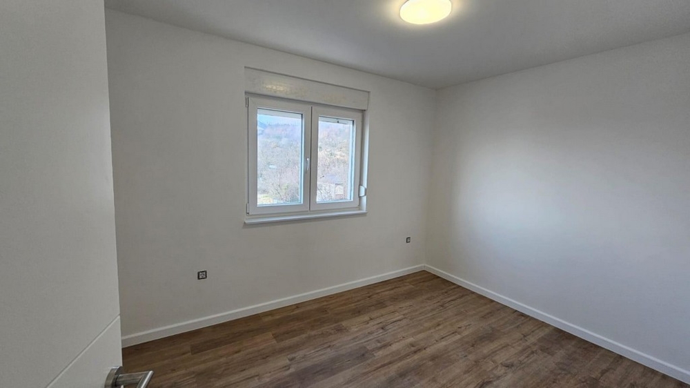 Pusta sypialnia w mieszkaniu na sprzedaż w Crikvenicy, Zatoka Kvarner, z drewnianymi podłogami i białymi ścianami