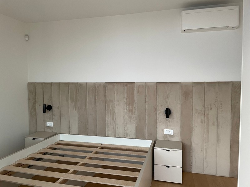 Minimalistyczna sypialnia z wbudowanym łóżkiem i klimatyzacją w mieszkaniu w Rijece.