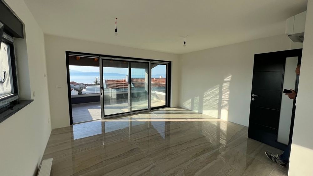 Jasny salon z bezpośrednim wyjściem na taras, charakterystyczny dla chorwackich nieruchomości.