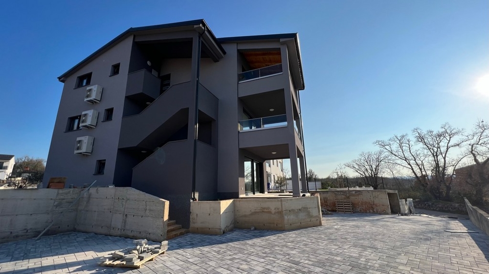 Widok na tył budynku mieszkalnego ukazujący spokojną lokalizację nieruchomości na wyspie Krk.