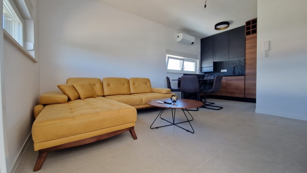 Wnętrze mieszkania w Novalji na wyspie Pag, z nowoczesnymi meblami i żółtą sofą, nieruchomość w Chorwacji