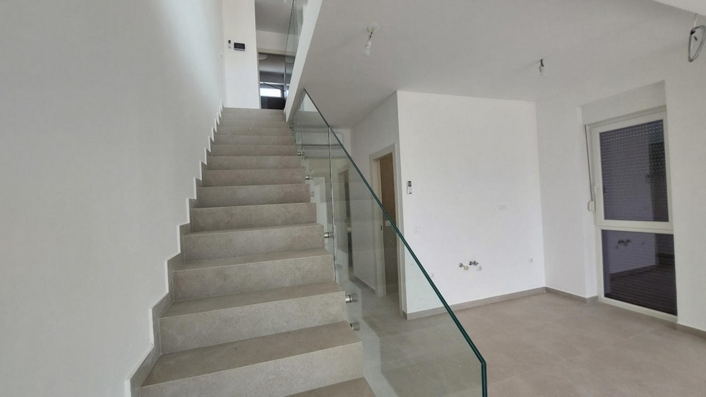 Korytarz z pomalowanymi na biało ścianami, klimatyzacją i drzwiami do innych pomieszczeń