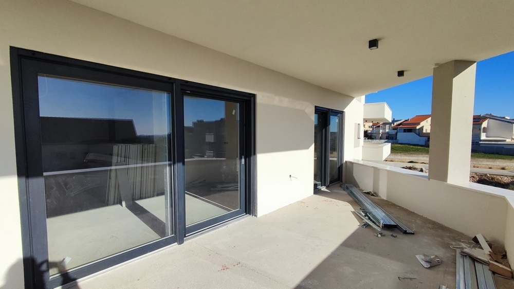 Niedokończony pokój z dwoma dużymi oknami z widokiem na morze