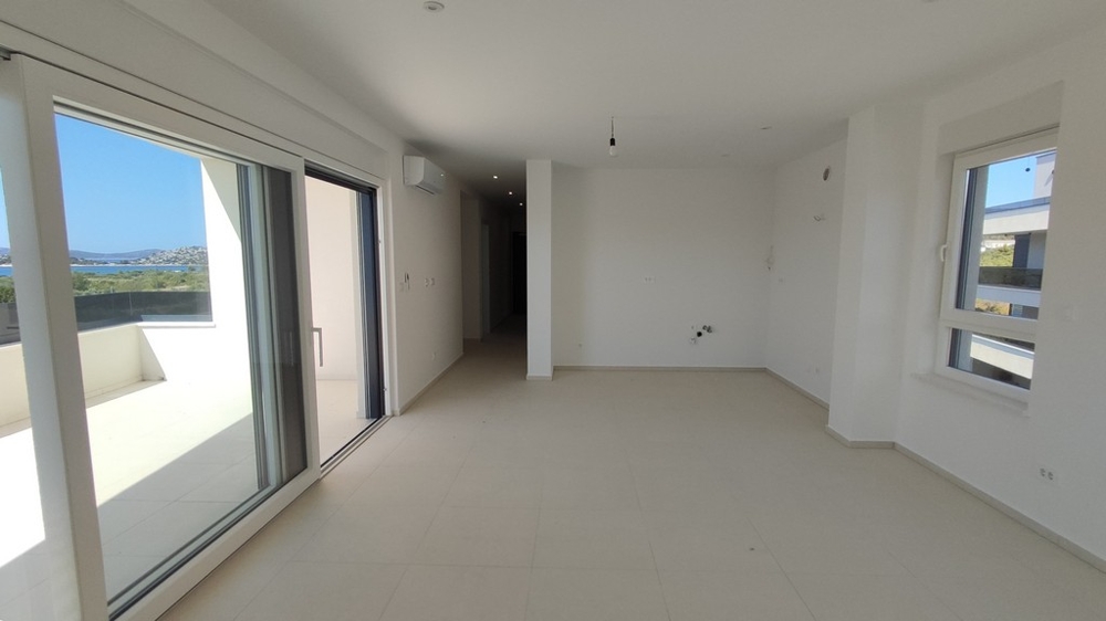 Niedokończony pokój z dwoma oknami i widokiem na morze