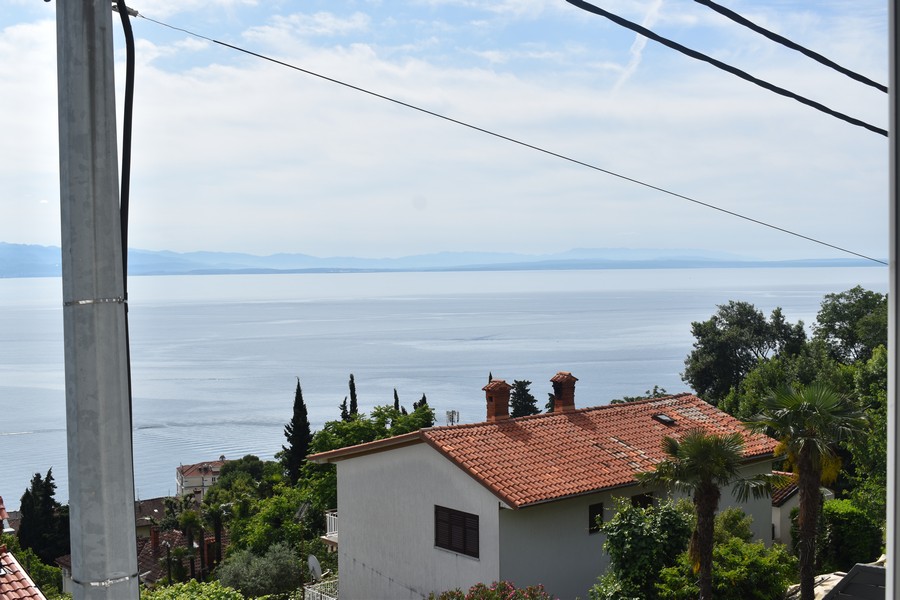 Widok z balkonu pokazuje morze i okolicę, podkreślając nieruchomość w Chorwacji