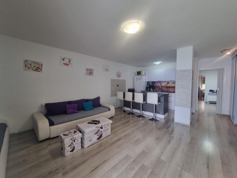 Otwarta część dzienna z nowoczesnym wyposażeniem i aneksem kuchennym w tle