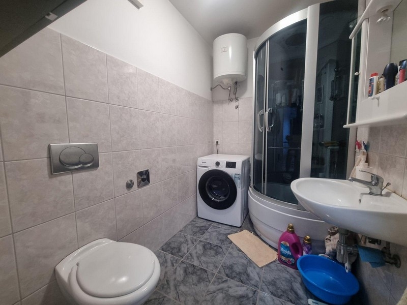 Łazienka z prysznicem, pralką i toaletą