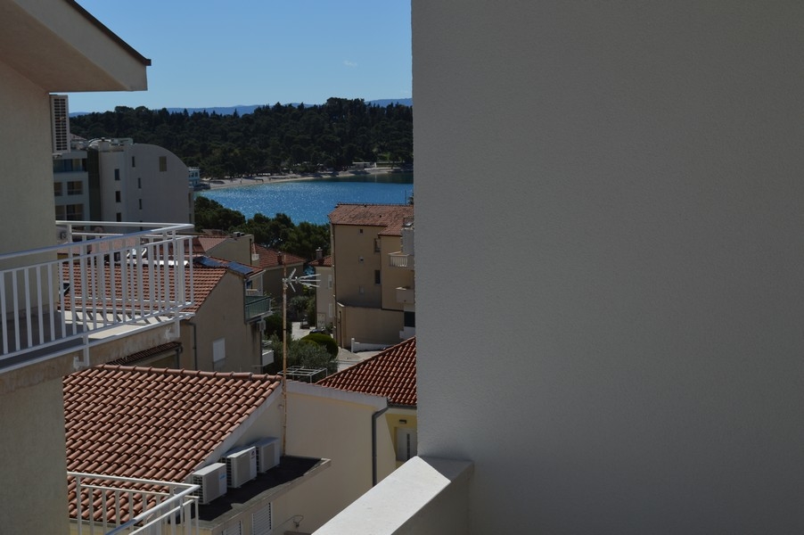 Częściowo zasłonięty widok na morze z balkonu niedokończonego mieszkania.