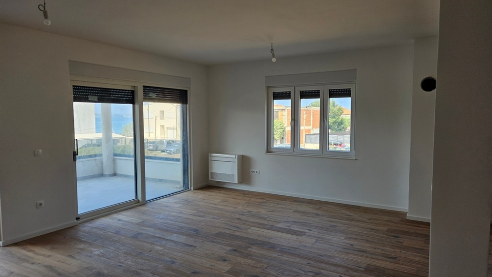 Część dzienna z parkietem i grzejnikiem na ścianie.