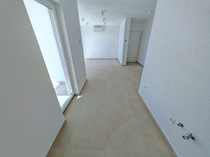 Widok z tyłu budynku mieszkalnego z miejscem parkingowym i zielonym otoczeniem w Smokvicy Krmpotskiej