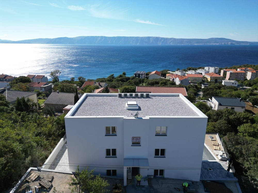 Widok z przodu nowoczesnego apartamentowca z balkonami i basenem w Smokvicy Krmpotskiej