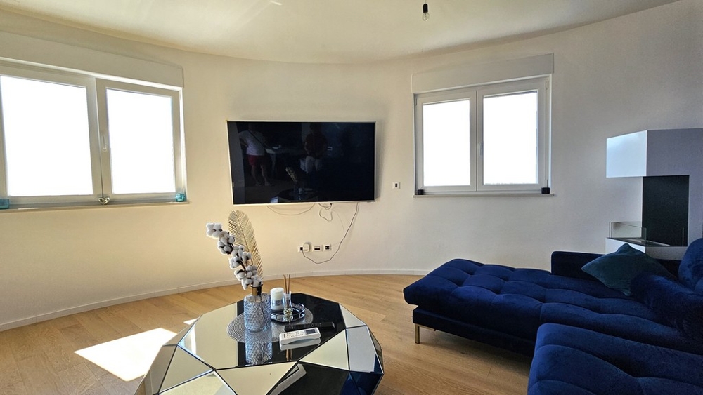 Pokój dzienny z dużymi oknami i niebieską sofą